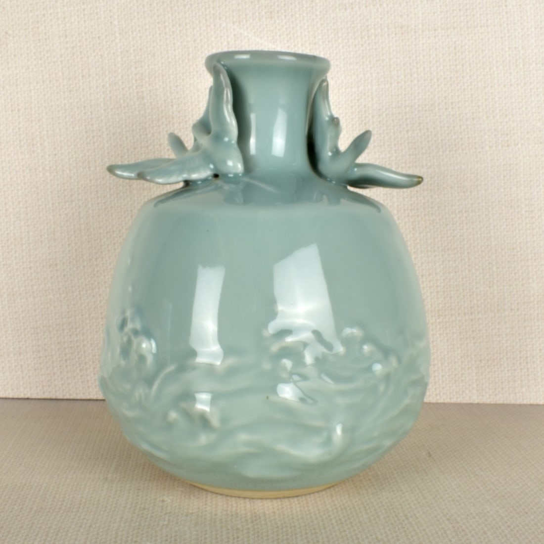 Japanese Studio Celadon Vase: Japanese Studio Porcelain Celadon Vase Decorated with Two (2) Geese Flying Over an Ocean in High Relief. Signed to the bottom. Measures: 7-1/2" H, 6-1/2" Dia. Kodner Galleries offers phone and absente