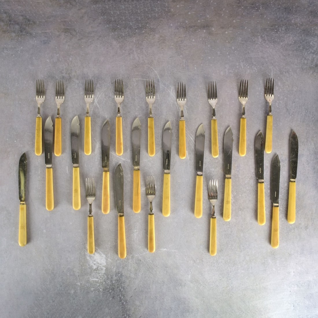 Antique English Fish Set: Twenty-four (24) Piece Antique English Silver Plate Fish Set with Bakelite Handles. Knives measure: 8-3/4" L., forks measures: 7-1/4" L. Kodner Galleries offers phone and absentee bidding at a low, fl