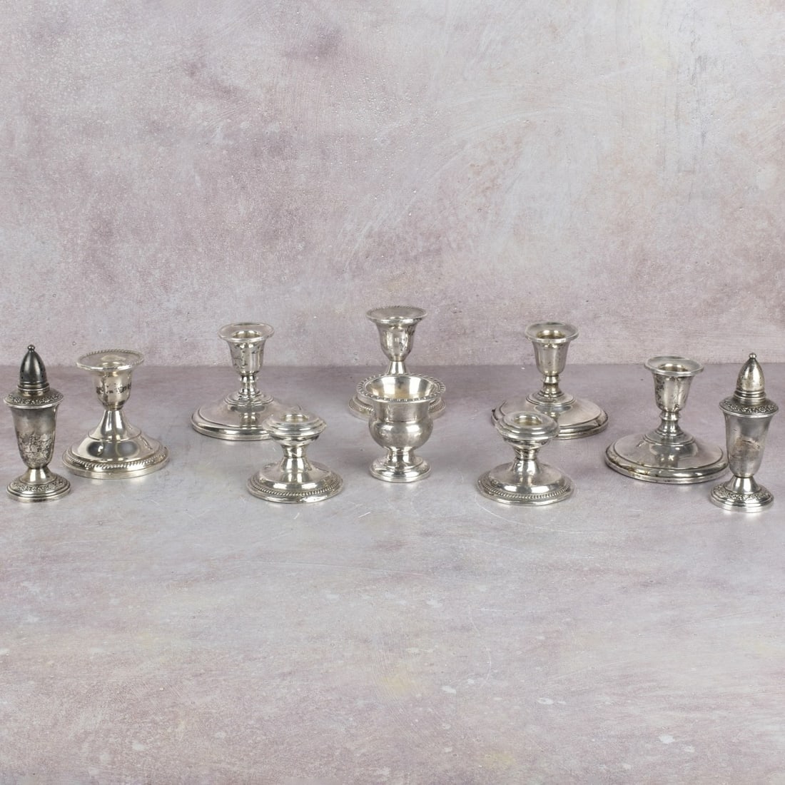 Weighted Sterling Silver Pieces: Weighted Sterling Silver Pieces. Including seven (7) candle holders, one (1) tooth pick holder, one (1) salt shaker, one (1) pepper shaker. Tallest measures: 3-1/4" high. All stamped "Sterling Weighte