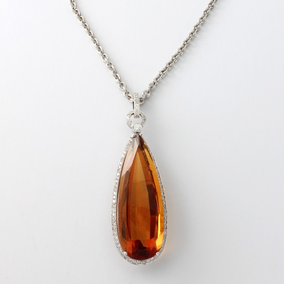 Citrine, Diamond and 18K Necklace: 33.35 Carat Elongated Pear Shape Gem Quality Gold Citrine, 2.0 Carat TW Round Brilliant Cut Diamond and 18 Karat White Gold Pendant Necklace. Citrine with vivid color. Diamonds F-G color, VS1