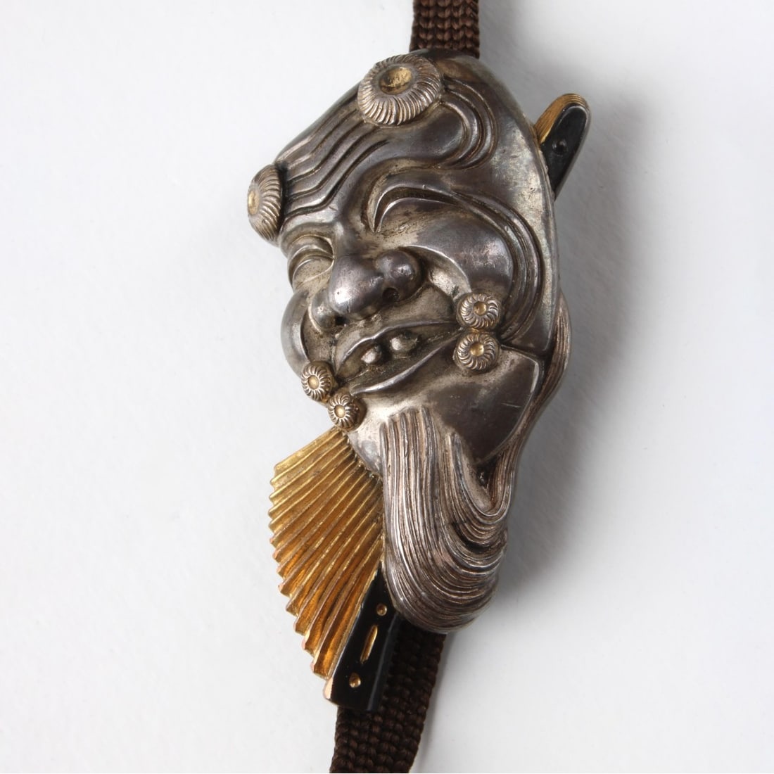 Japanese Meiji Silver Pendant: Japanese Meiji Pure Silver and Gilt Silver Okina Noh Mask Pendant on a Cord. Metal back. Measures 1-7/8" L, 1" W. Approx. gross weight: 18.16 grams. Kodner Galleries offers phone and absentee bidding 