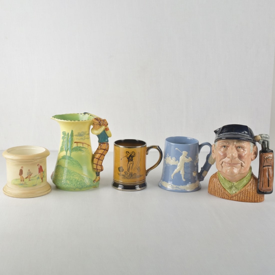 Vintage Golf Items: Five (5) Vintage Porcelain Golf Items. Consisting of one (1) Burleigh Ware England figural jug, measures: 7-3/4" high, one (1) Royal Doulton "Golfer" Toby mug, measures: 8" high, one (1) Arthur Wood