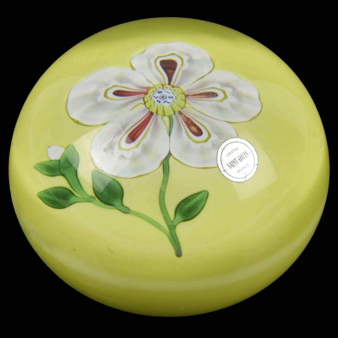 Vintage Saint-Louis Glass Paperweight: Vintage Saint-Louis Floral Art Glass Paperweight. Decorated with a large central five-pedal flower with red stripes and a yellow signature cane dated "1973" with a green stem and green leaves having a