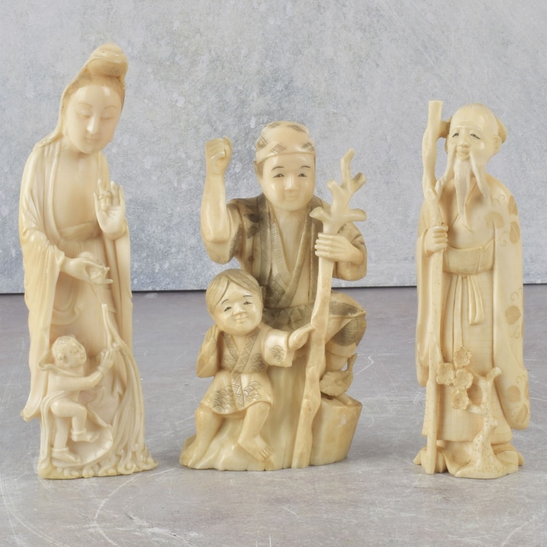 Antique Carved Japanese Figures: Three (3) Antique Carved Japanese Figures. Figure of man with staff artist signed. Woman with child measures: 6" high, 1-3/4" wide, 1-1/4" deep. We Will Not Ship This Item Outside of the State of
