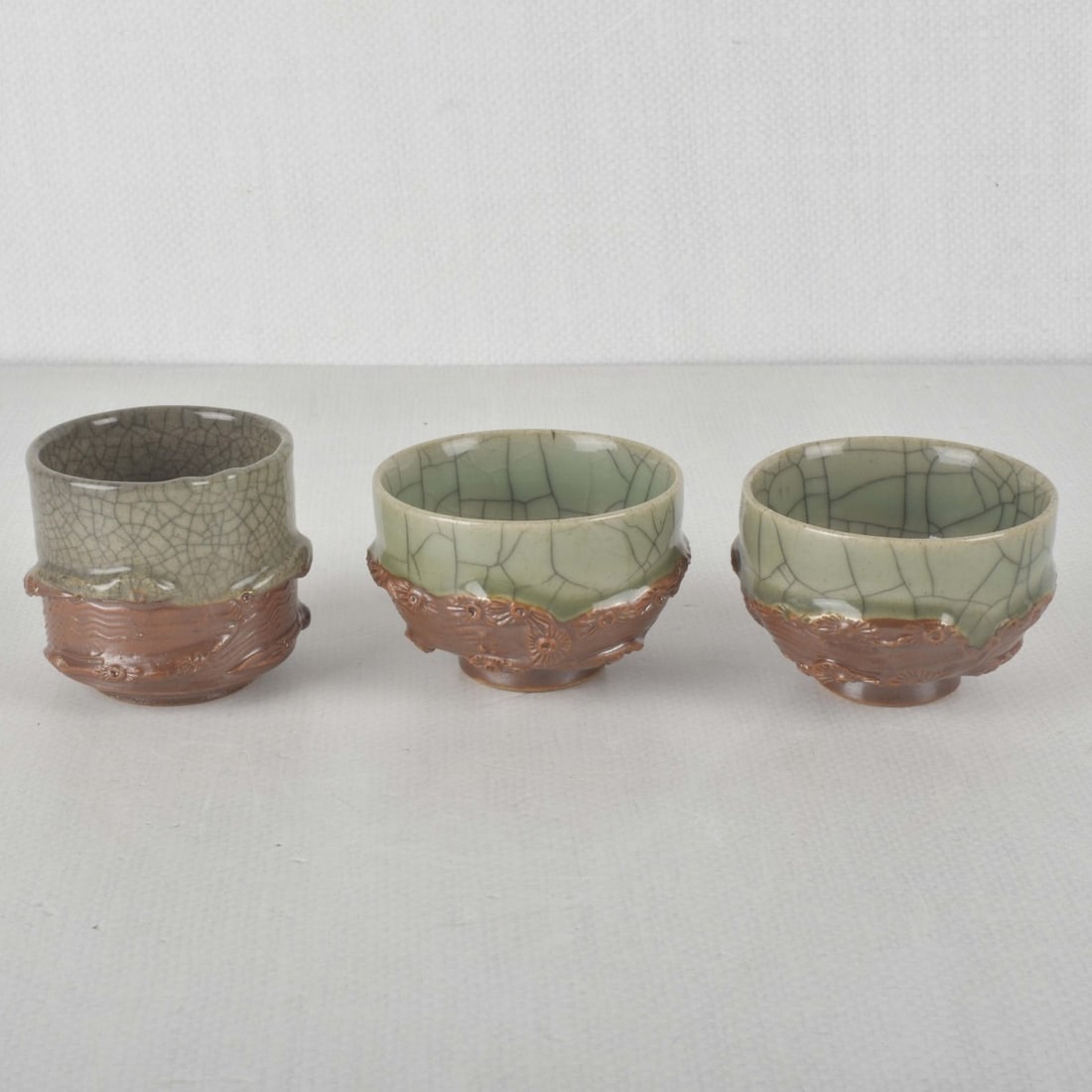 Korean Porcelain Pieces: Antique Collection of Three (3) Korean Porcelain Pieces. Consisting of three (3) green crackle glaze with baked red bisque bottoms (2 small of the same form, 1 of a different form), largest measures: 