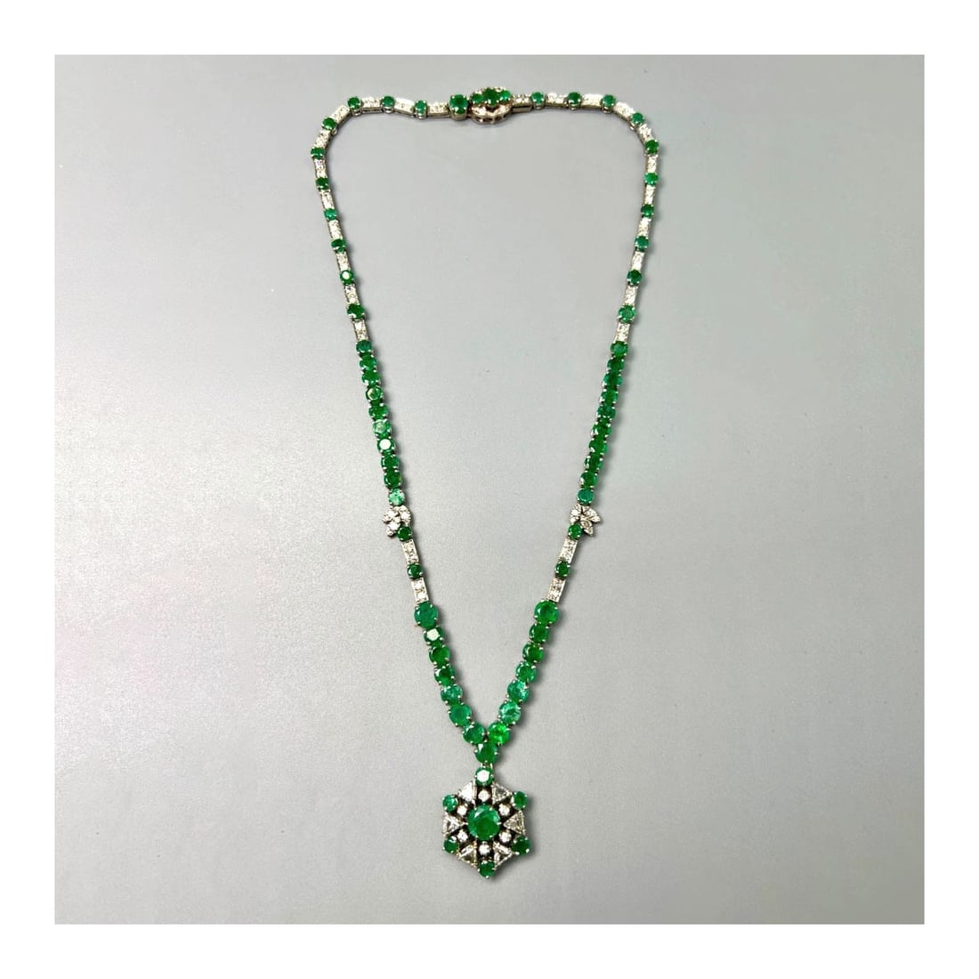 Emerald, Diamond and 14K Necklace: Vintage Circa 1950s Approx. 20.0 Carat TW Round Cut Emerald, 1.50 Carat TW Six (6) Triangular Cut Diamonds, 2.50 Carat TW Eighty Round Cut Diamonds and 14 Karat White Gold Pendant Necklace. Emeralds