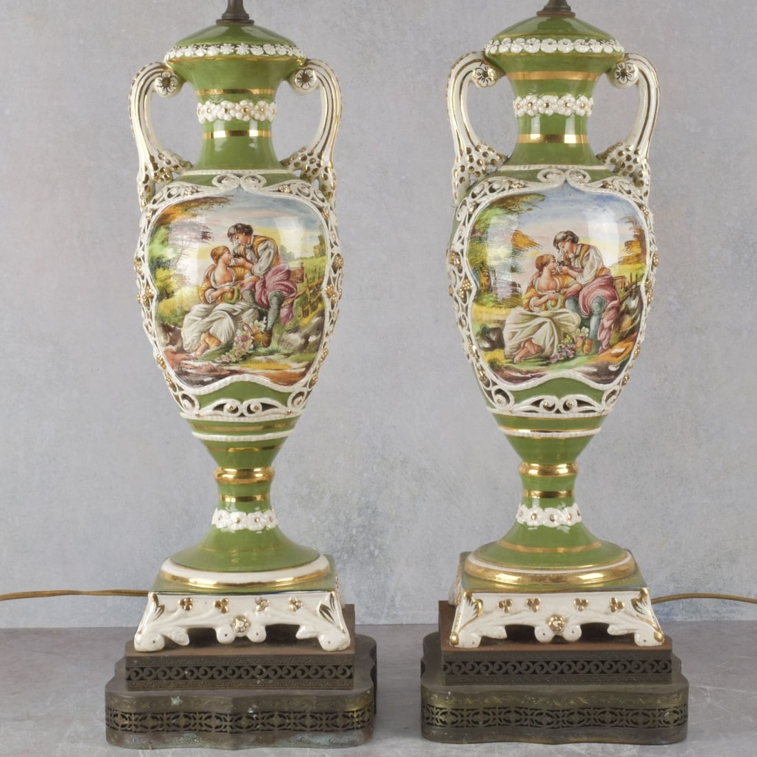Large Pair of Porcelain Lamps: Large Mid 20th Century Pair of Italian Hand Painted and Parcel Gilt Reticulated Porcelain Urn Lamps on Metal Bases. Urns measure 18: H, overall measure 30" H, 7-1/2" W at base. Kodner Galleries