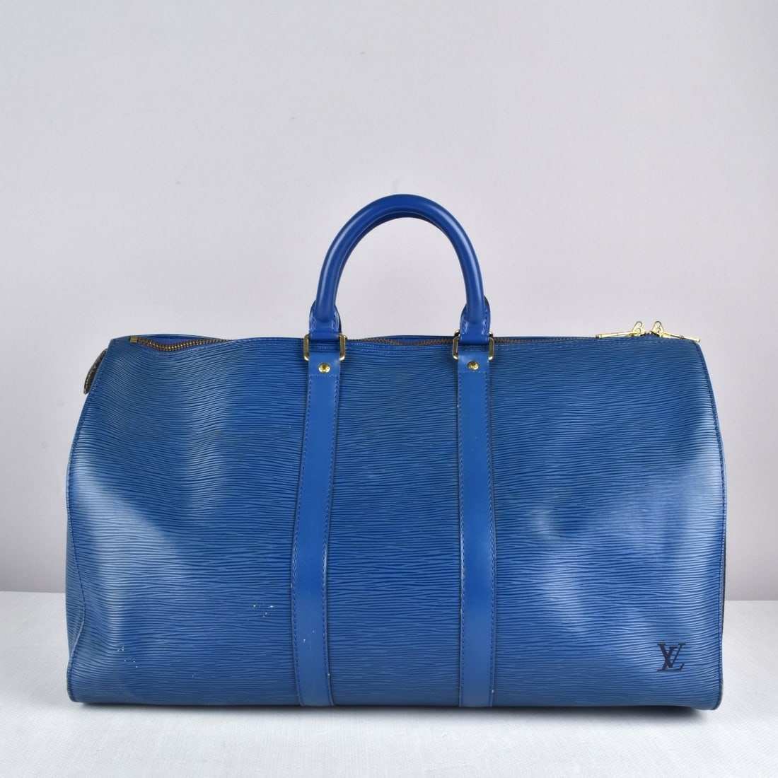 Louis Vuitton "Keepall" Bag: Louis Vuitton "Keepall" Blue Leather Bag. Measures: 11" H, 18" W, 7-1/2" D. Kodner Galleries offers phone and absentee bidding at a low, flat 21% buyer?s premium without surcharge or hidden fees. For