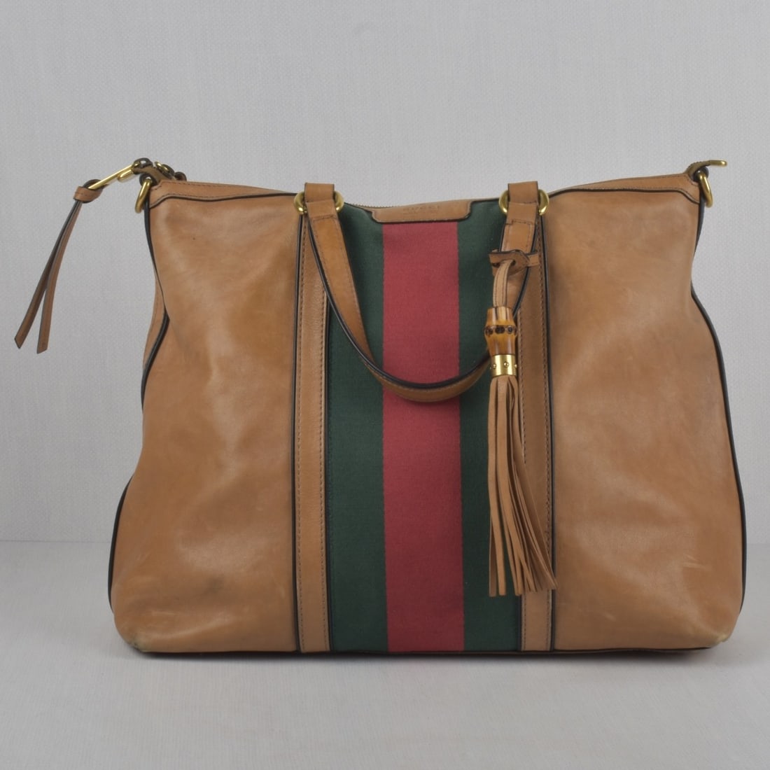 Gucci Handbag: Gucci Light Brown Calfskin Rania Handbag with Gold Tone Hardware. Measures: 12" high, 16" wide, 6-1/2" deep, drop measures: 6-1/4". Kodner Galleries offers phone and absentee bidding at a low, flat