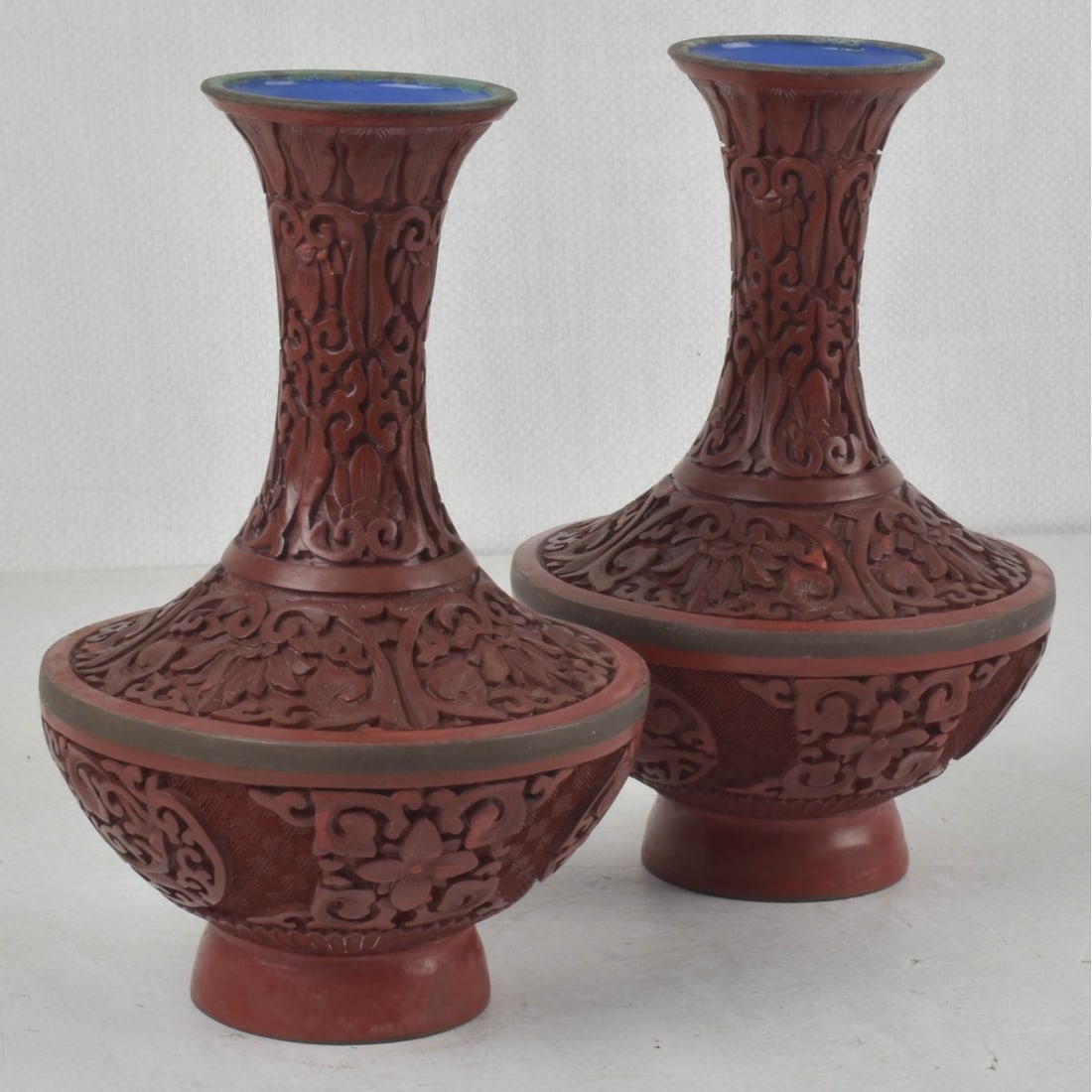 Pair of Chinese Cinnabar Vases: Vintage Pair of Chinese Carved Floral Red Cinnabar Vases with Royal Blue Enameled Interior. Measures: 8" high, 5" diameter. Kodner Galleries offers phone and absentee bidding at a low, flat 21%