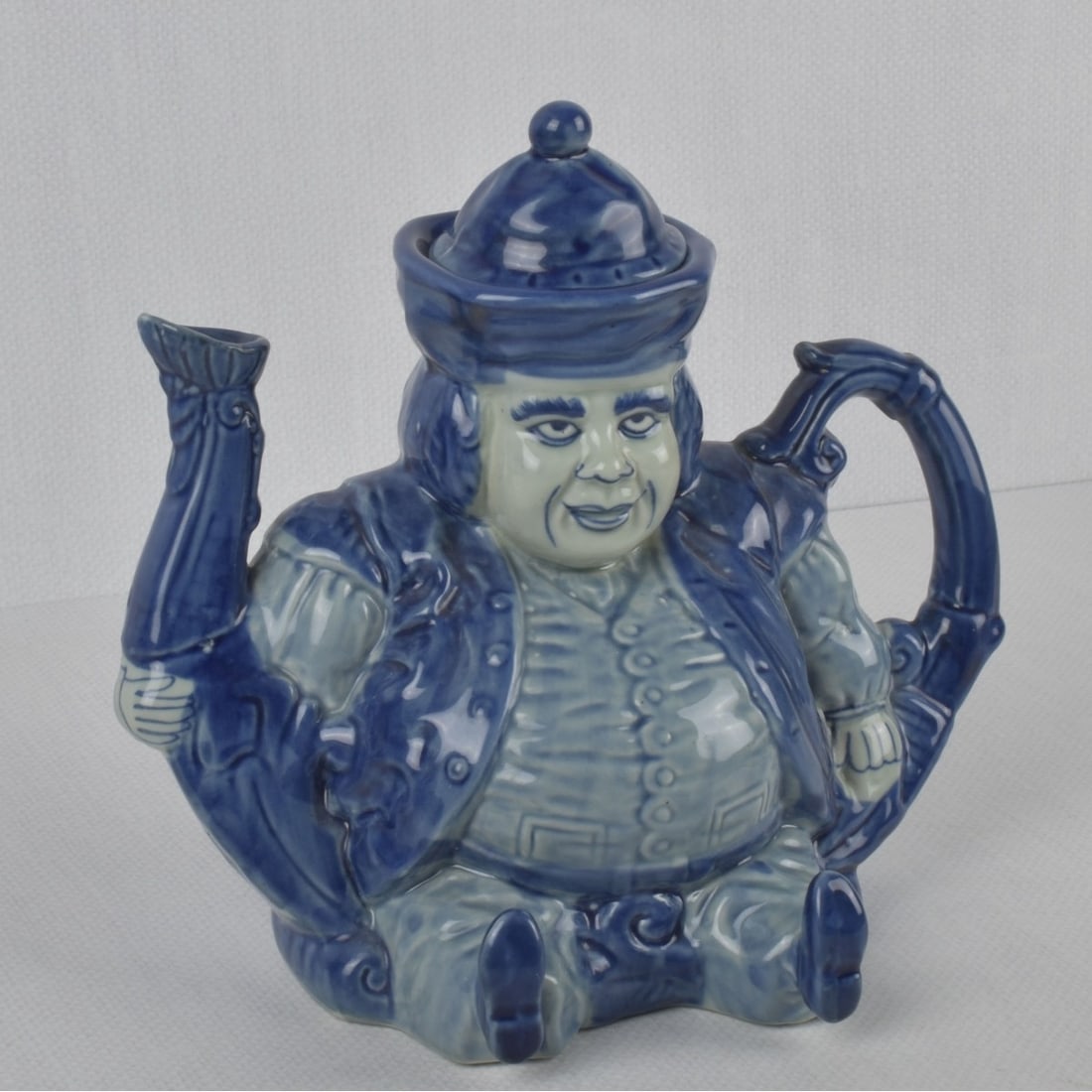 Victoria Ironstone Toby Teapot: Victoria Ironstone Toby Teapot Depicting a Figural Seating Man in a Dark Blue Glaze as the Hat Serves as a Lid. Properly marked to the bottom. Measures: 9" high, 9" wide, 6" deep. Kodner Galleries