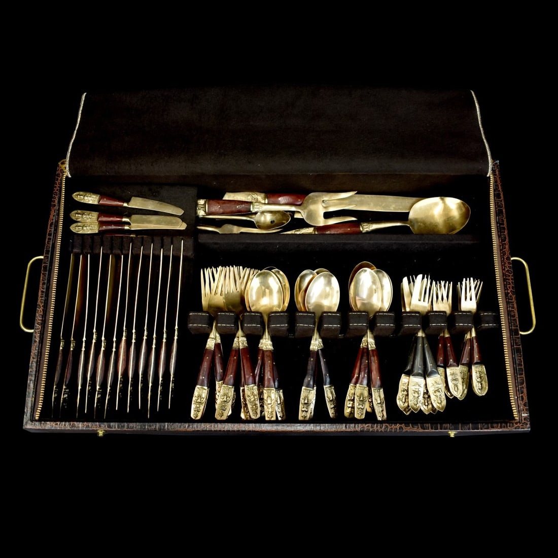 Thai Flatware Set: Seventy Five Piece Vintage Thai Brass and Wood Assembled Flatware Set. Includes (12) knives measuring 8-1/8", (12) forks measuring 7-1/2", (12) round bowl spoons, (11) seafood forks, (6) desert