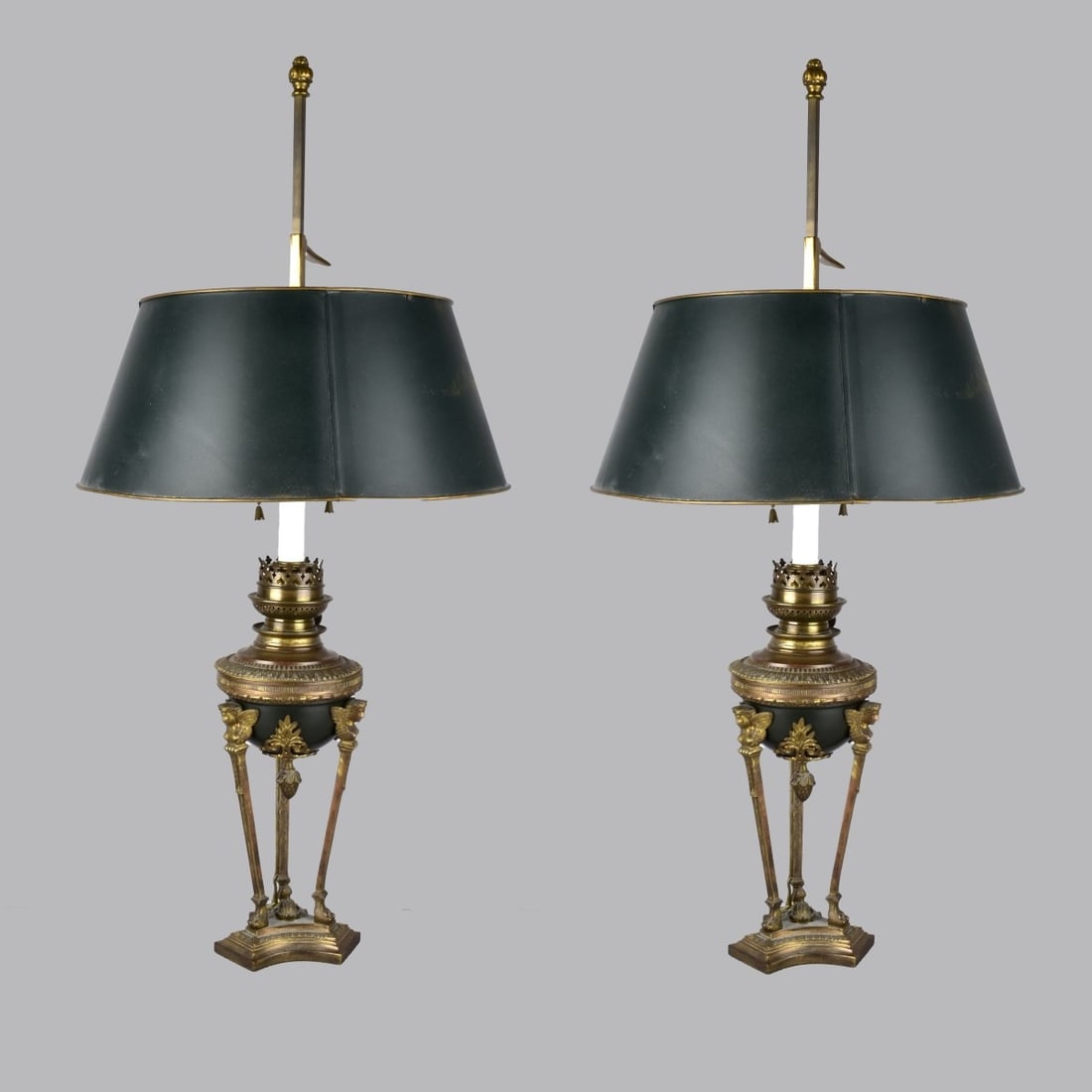 French Empire Style Table Lamps: Pair of French Empire Style Bronze Table Lamps with Telescoping Tole Shades. Each lamp supported on three (3) extended paw feet and ending in winged angel masks faces. Most likely converted from keros