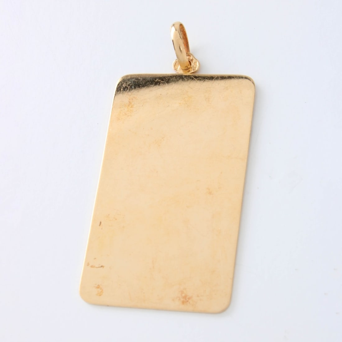 14K Dog Tag Pendant: Vintage 14 Karat Yellow Gold Dog Tag style Pendant. Measures 2" L, 1" W. Approx. weight: 15.01 grams. Kodner Galleries offers phone and absentee bidding at a low, flat 21% buyer?s premium without