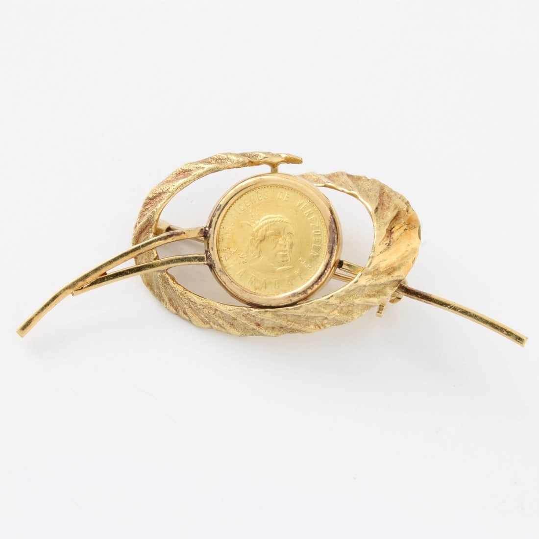Gold Coin and 18K Pin: Vintage Venezuela Terepaima Gold 5 Bolivares Caciques Indian Chiefs Head Gold Coin and 18 Karat Yellow Gold Pin. Measures 1" H, 2" W. Approx. total weight: 8.11 grams. Kodner Galleries offers phone