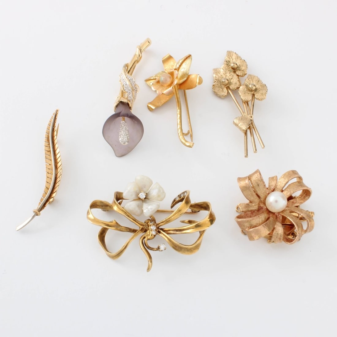 14K Pins: Collection of Six (6) Floral Design 14 Karat Yellow Gold Pins. Various accented with cultured pearls, crystal and mother of pearl. Stamped 14K. Largest measures 1". Approx. total weight: 11.6 grams. K