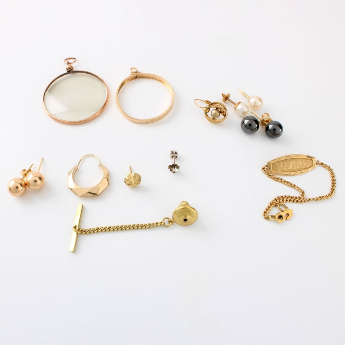Scrap Gold Lot: Mixed Lot of Scrap Gold. To include miscellaneous pieces of 10, 14, and 18 karat yellow gold. Some are stamped 14K or 18K. One item with glass from a frame or locket. Approx. total gross weight: 7.65