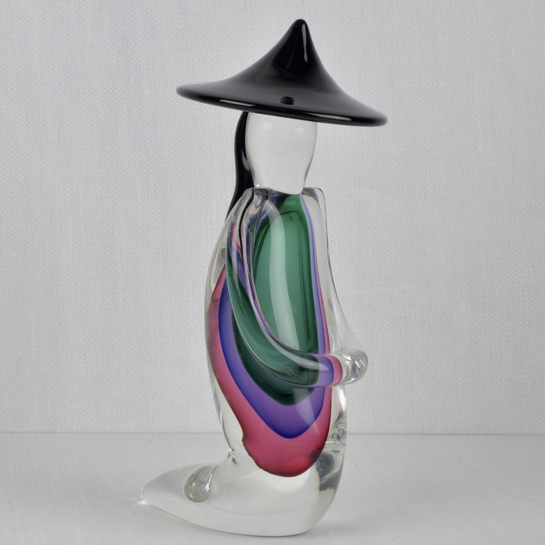 Luigi Onesto, Italian (born 1935): Luigi Onesto, Italian (born 1935) Murano Sommerso Glass Sculpture of a Meditating Monk with a Conical Hat and Crossed Hands. Late 20th Century, Signed in script to the bottom. Measures: 11-1/2" high,