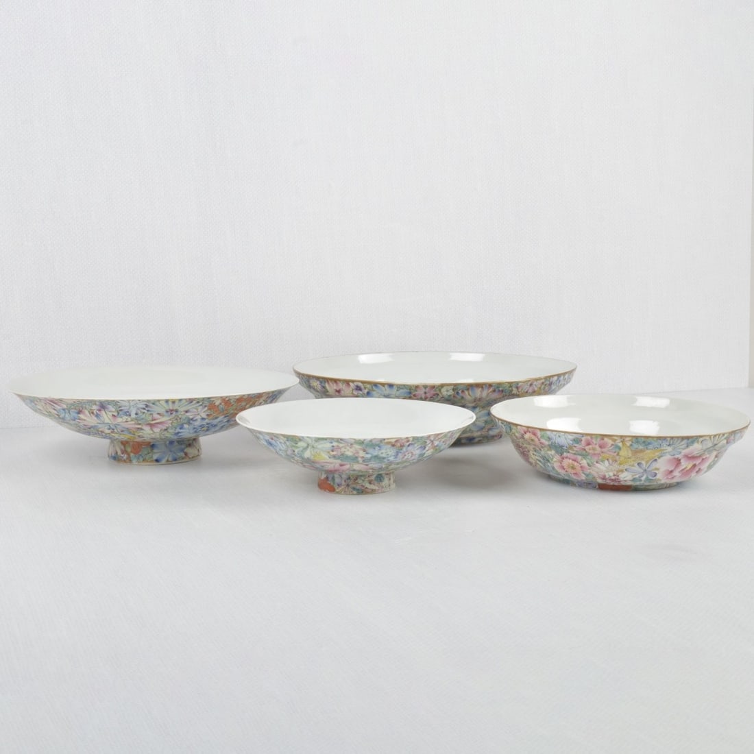 Vintage Chinese Mille Fleur Bowls: Four (4) Vintage Chinese Mille Fleur Porcelain Bowls. Bottoms bear the Qianlong reign mark and two (2) with wax seals to the bottoms. Largest measures: 2-1/2" high, 9-1/4" diameter, smallest footed bo