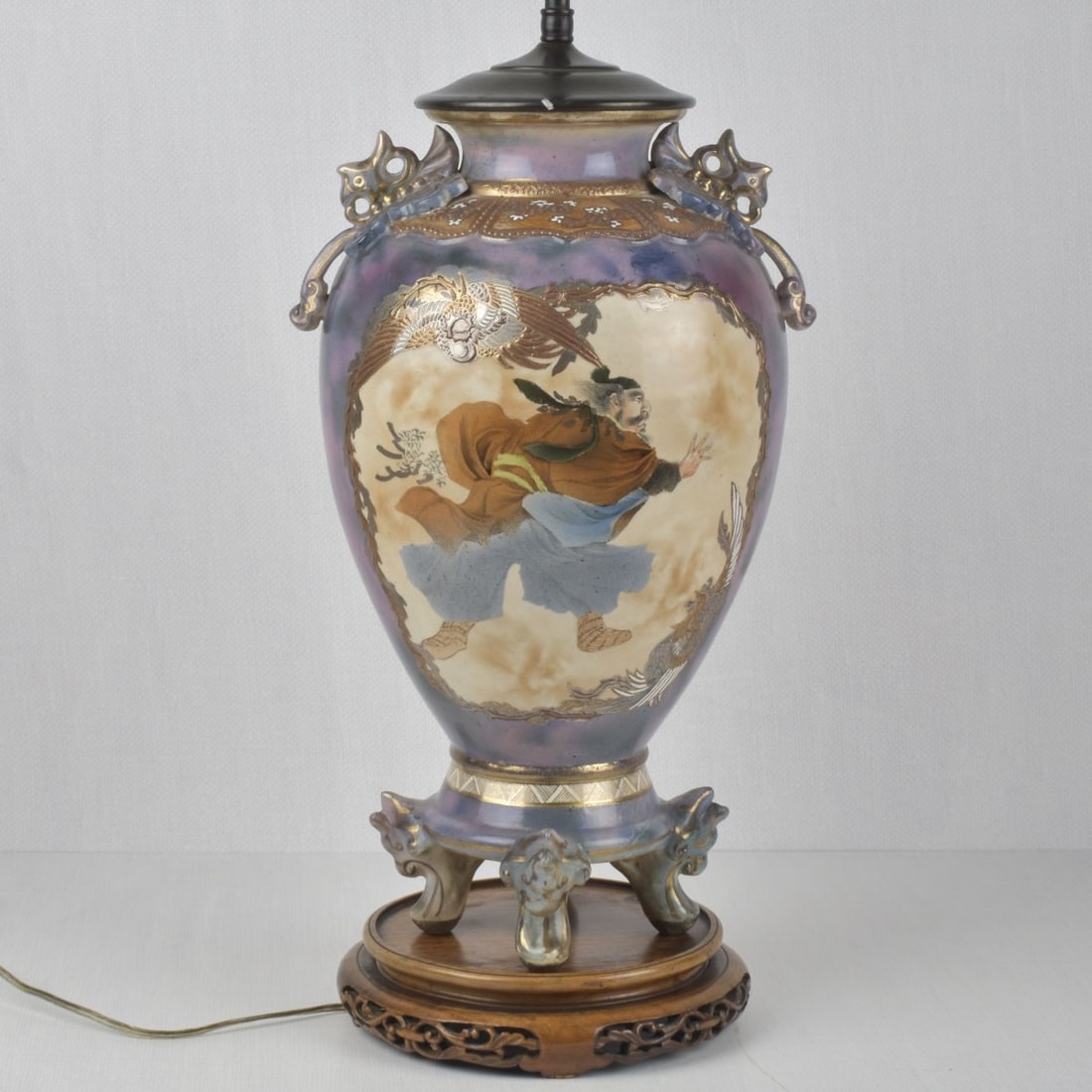 Japanese Porcelain Lamp: Japanese Satsuma-style or Kutani-style Hand Painted Porcelain Lamp with a Samurai Figure on one side and a large Flower to Other Side. Porcelain portion measures: 16-3/4" high, 10-1/2" diameter.