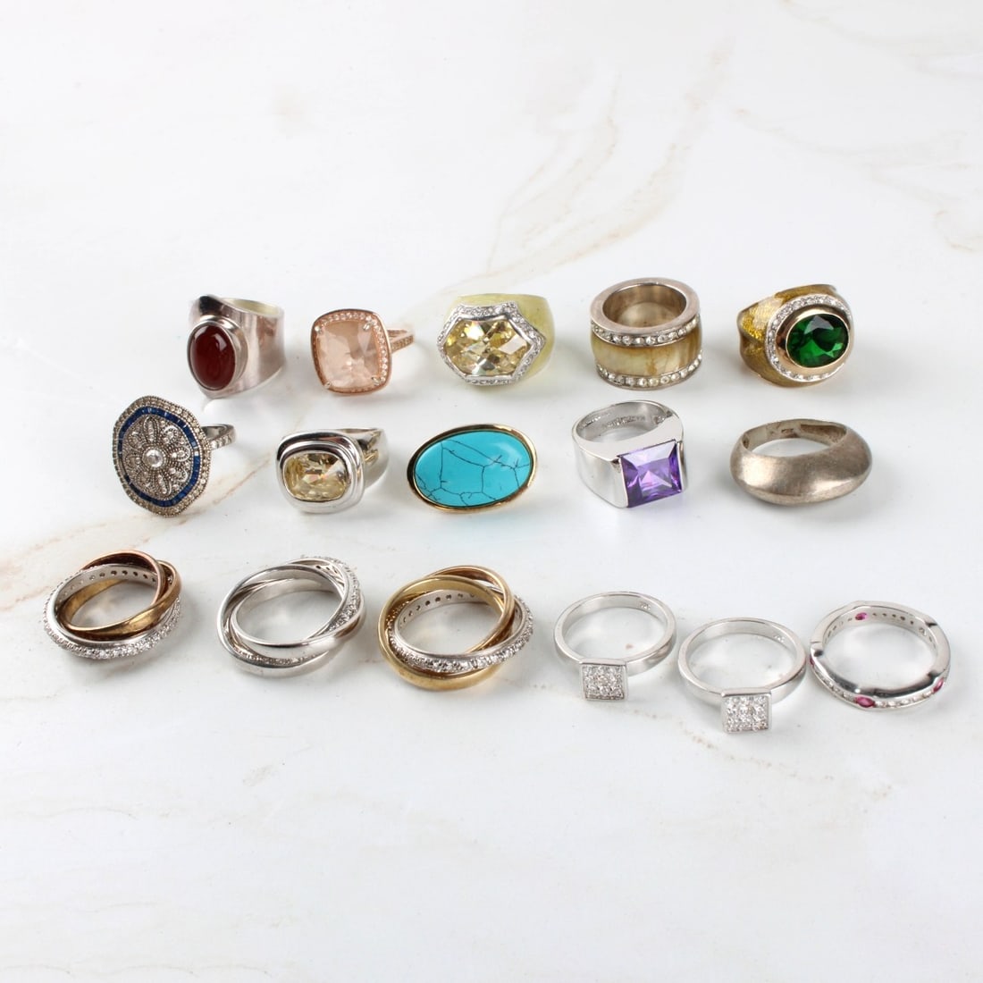 Sterling Silver Rings: Collection of Sixteen (16) Sterling Silver Rings. Some with faux diamonds, stones. Total weight: 117.01 grams. Kodner Galleries offers phone and absentee bidding at a low, flat 21% buyer?s premium