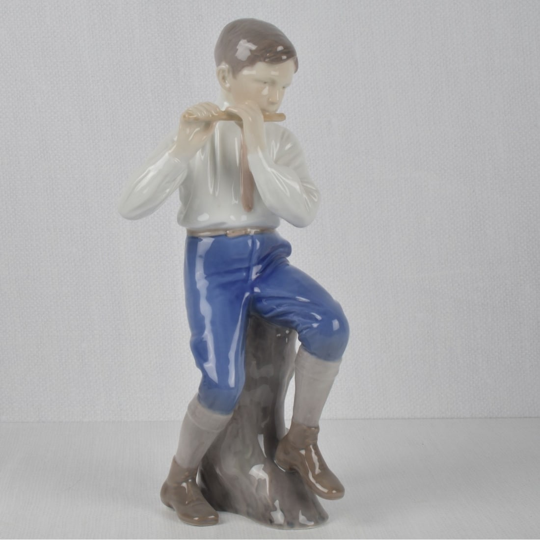 B & G/Royal Copenhagen Porcelain Figure: Bing & Grondah - Royal Copenhagen Porcelain Figure # 1897 "Flute Player". Properly marked to the underside. Measures: 11-3/4" high, 4" wide, 4-3/4" deep. Kodner Galleries offers phone and absentee