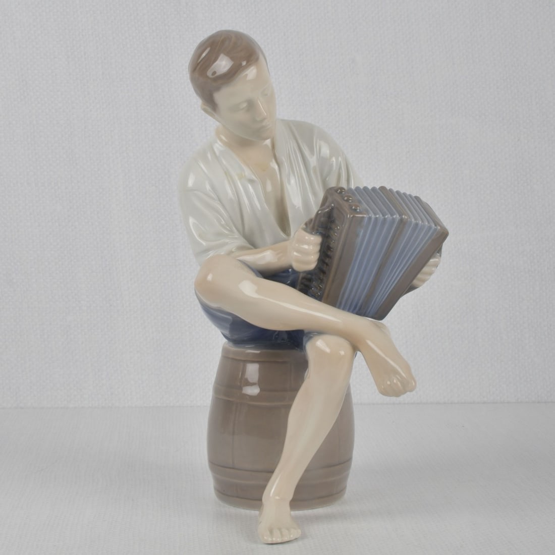 B & G/Royal Copenhagen Porcelain Figure: Bing & Grondah - Royal Copenhagen Porcelain Figure # 1661 "Accordion Player". Properly marked to the underside. Measures: 9" high, 4-1/2" wide, 5" deep. Kodner Galleries offers phone and absentee