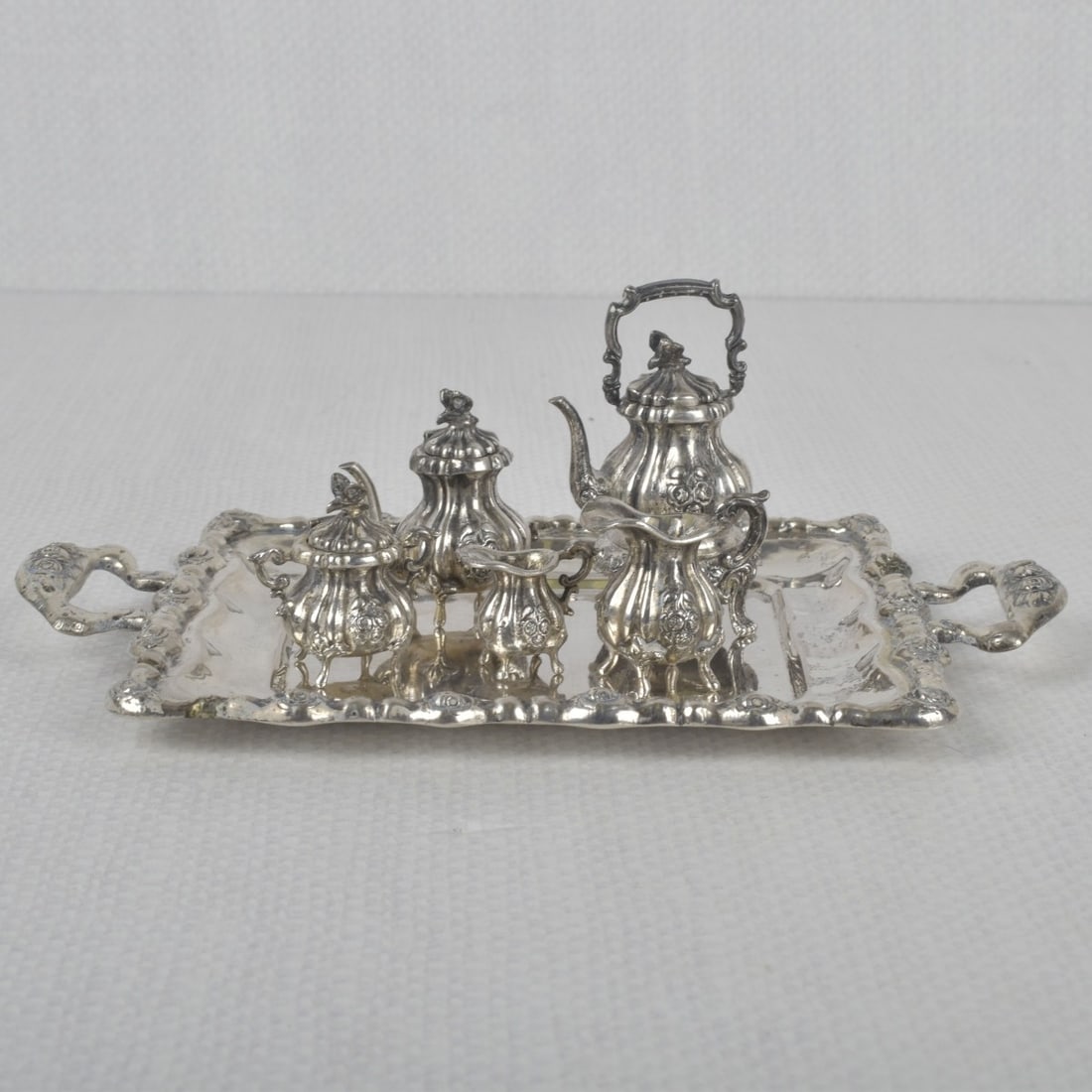 Mini Sterling Silver Tea Set: Antique Mini Six (6) Piece Sterling Silver Tea Set. All properly stamped. Largest kettle measures: 1-1/2" high. Total weight 210.50 grams. Kodner Galleries offers phone and absentee bidding at a low, 