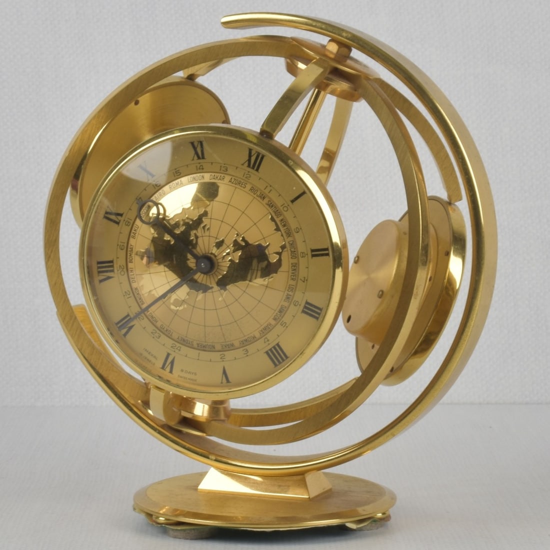 Imexal Armillary World Clock: Imexal Armillary Swiss Made 8 Jewel Brass World Time Desk Clock with Thermometer and Barometer. Measures: 8" high, 6-1/2" wide, 7-1/2" deep. Kodner Galleries offers phone and absentee bidding at a