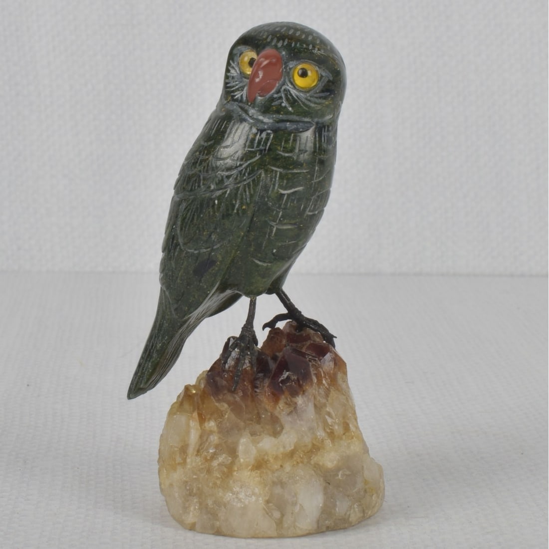 Carved Stone Owl Sculpture: Hand Carved Stone Owl Sculpture Perched on a Quartz Rock. Overall measures: 4" high, 2-1/4" wide, 2" deep. Kodner Galleries offers phone and absentee bidding at a low, flat 21% buyer?s premium without