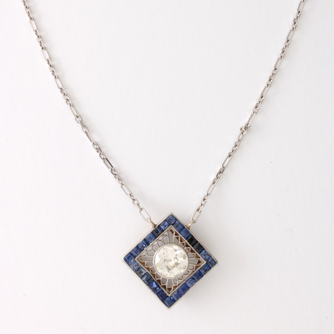 Deco Diamond, Sapphire and 14K Necklace: Art Deco Circa 1920s Approx. 1.50 Carat Old European Cut Diamond, 2.50-2.60 Carat TW Invisible Set Sapphire and 14 Karat White Gold Pendant Necklace. Diamond H-I color, VS2 clarity. Nice quality
