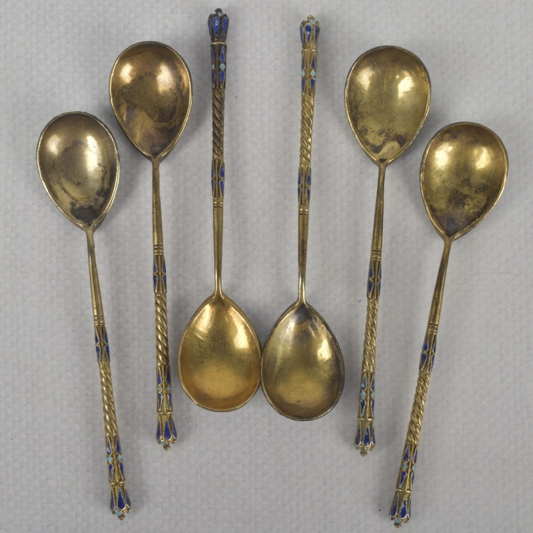 Antique Gold-wash Russian 84 Silver Spoons: SIx (6) Nikolai Zverev Antique Gold-wash Russian 84 Silver Spoons with Twisted Handle and Enameled Knop Finials Decorated with a Floral Design. Each with the mark of Nokolai Zverey to the side handle.