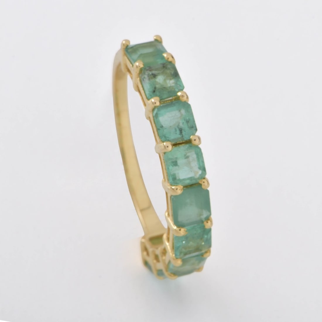 Emerald and 14K Eternity Band: Emerald and 14 Karat Yellow Gold Eternity Band. Set with nine baguette cut emeralds. Emeralds with good color, Stamped 585. Ring size 6. Approx. weight: 1.92 grams. Kodner Galleries offers phone and