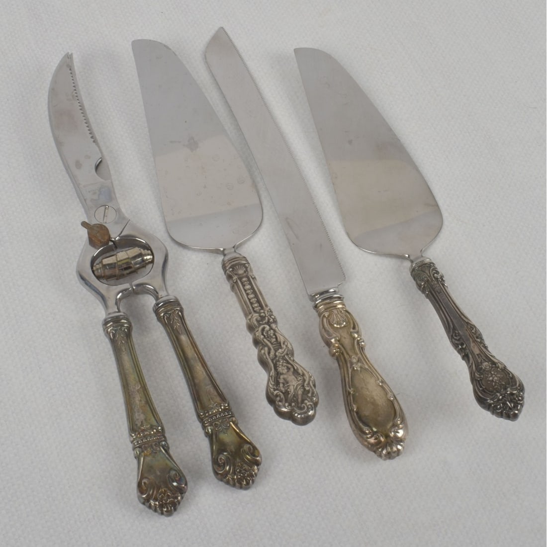 Sterling Silver Serving Pieces: Sterling Silver and Stainless Steel Serving Pieces of Various Makers and Patterns. Comprising: 1 large pair of shears, measures: 11-1/4" long, 1 cake knife: measures: 11-5/8" long, 2 cake/pie