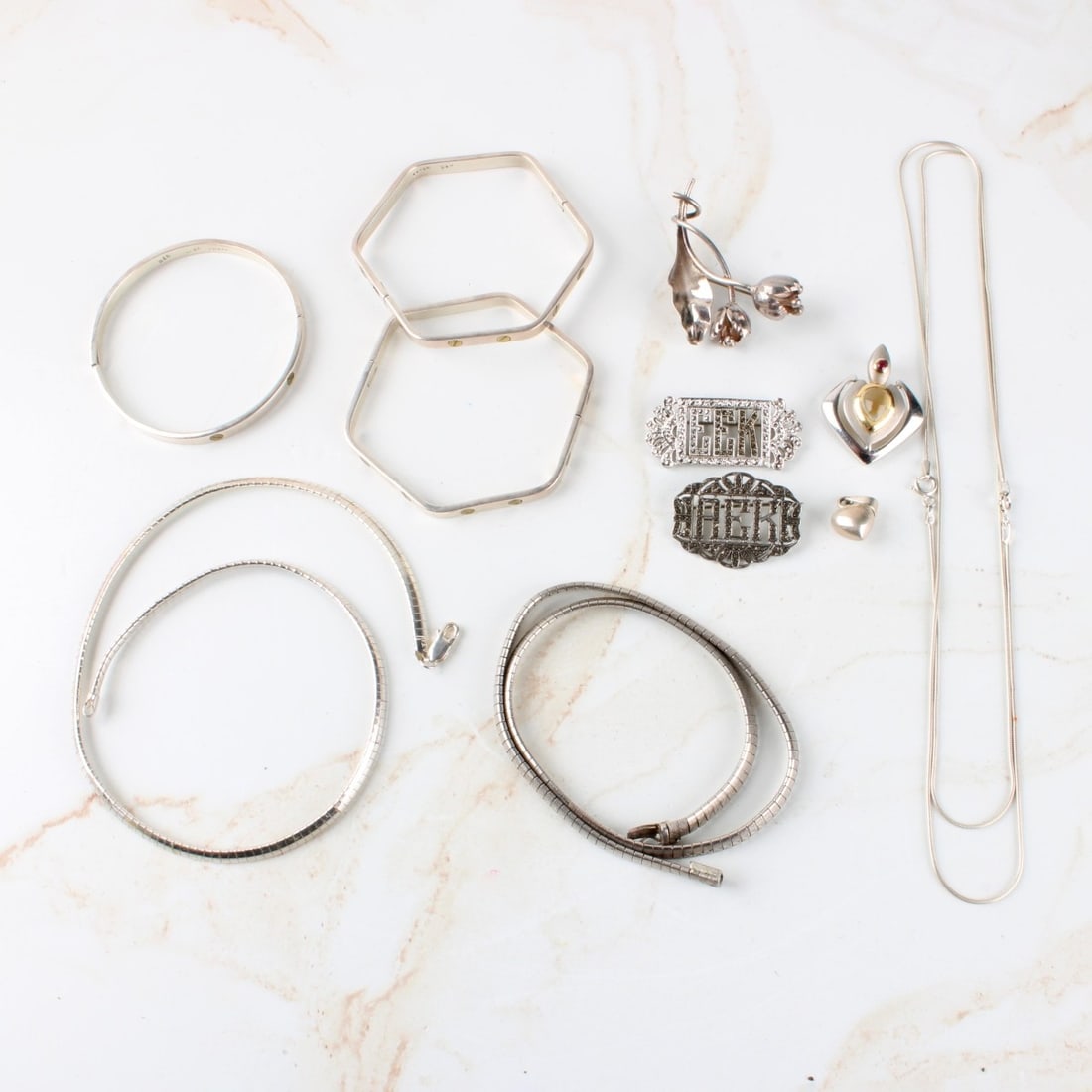 Lot of Sterling SIlver: Lot of Sterling Silver. Including necklaces, rings bracelets and pin. Total gross weight: 143.01 grams. Kodner Galleries offers phone and absentee bidding at a low, flat 21% buyer?s premium without