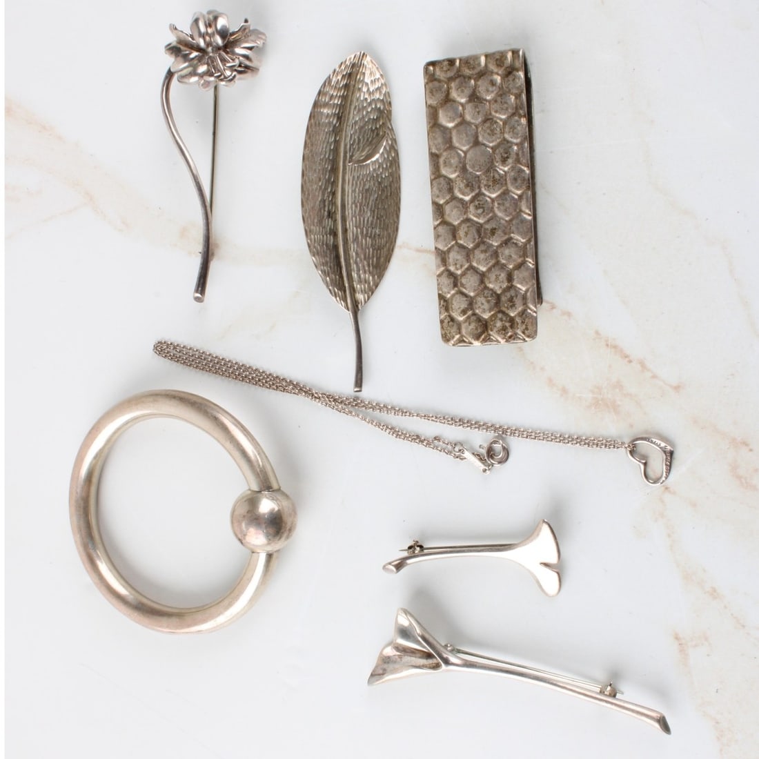 Tiffany & Co Sterling Silver Pieces: Seven (7) Pieces Tiffany & Co Sterling Silver Pieces. All pieces properly stamped. Consisting of one (1) baby teething rattle, measures: 2-1/8" diameter, one (1) honeycomb money clip, measures: