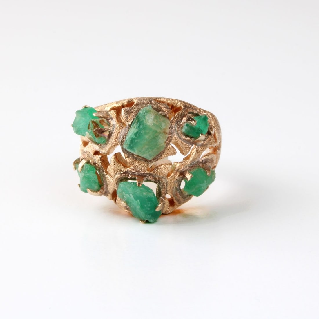 Emerald and 14K Ring: Vintage Rough Cut Natural Emerald and Textured 14 Karat Yellow Gold Ring. Stamped Mexico 14K. Ring size 8-1/2. Approx. weight: 12.45 grams. Kodner Galleries offers phone and absentee bidding at a