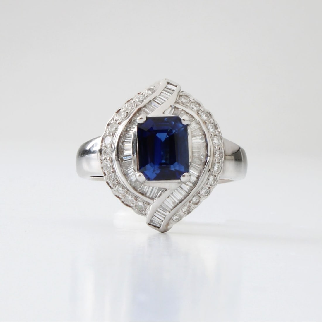 Sapphire, Diamond and 18K Ring: Vintage Approx. 2.20 Carat Emerald Cut Fine Quality Sapphire, 1.20 Carat TW Baguette and Round Brilliant Cut Diamond and 18 Karat White Gold Ring. Sapphire with vivid color. Diamonds F-G color,