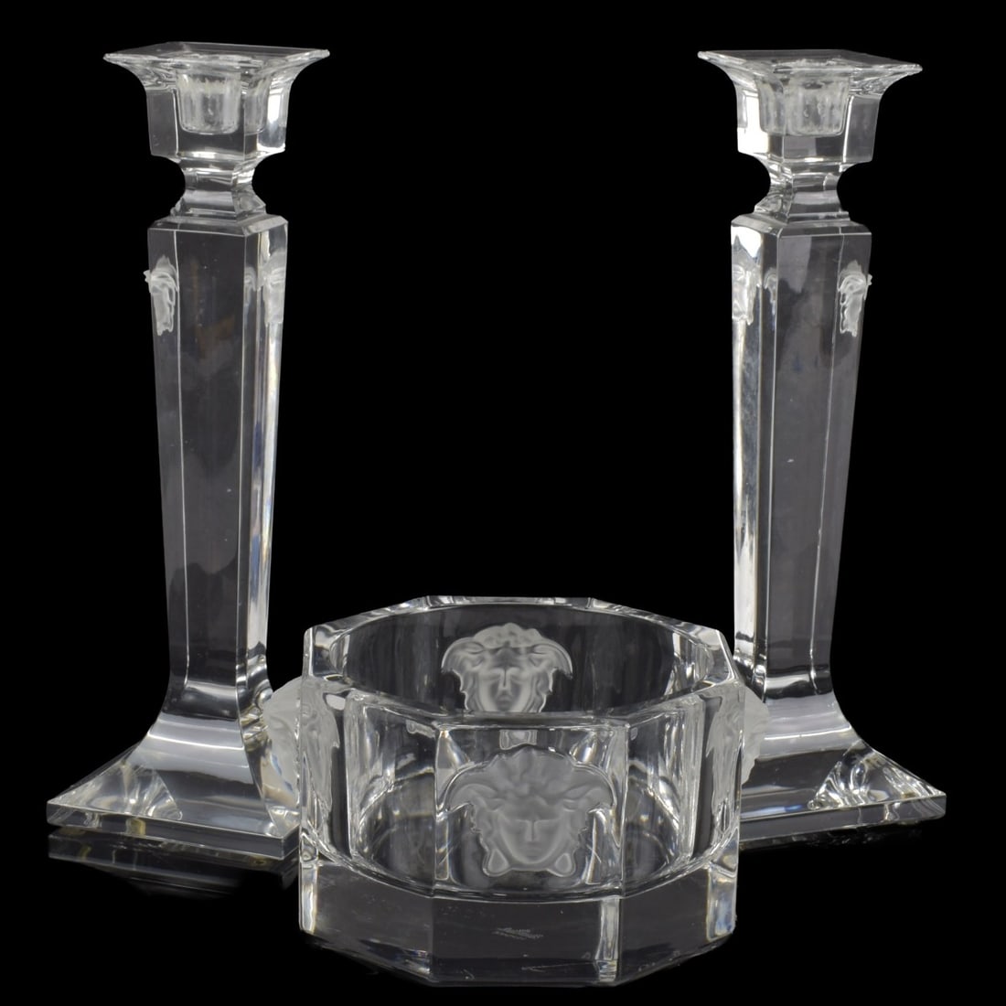 Versace Rosenthal Crystal Pieces: Versace Rosenthal Crystal Pieces. Consisting of one (1) pair of Medusa mask face candlesticks measures: 9-3/4" high, foot measures: 3-1/4" square, one (1) Medusa mask face wine bottle coaster