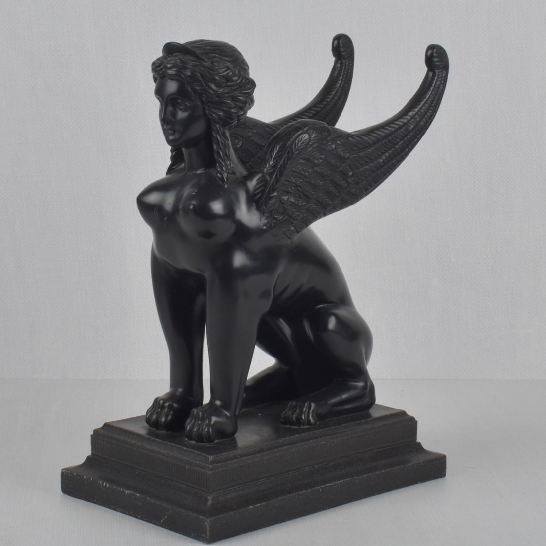 Sphinx Sculpture: Sphinx Composition Sculpture on a Faux Marble Base. Overall measures: 14" high, 10" wide, 7" deep. Kodner Galleries offers phone and absentee bidding at a low, flat 21% buyer?s premium without