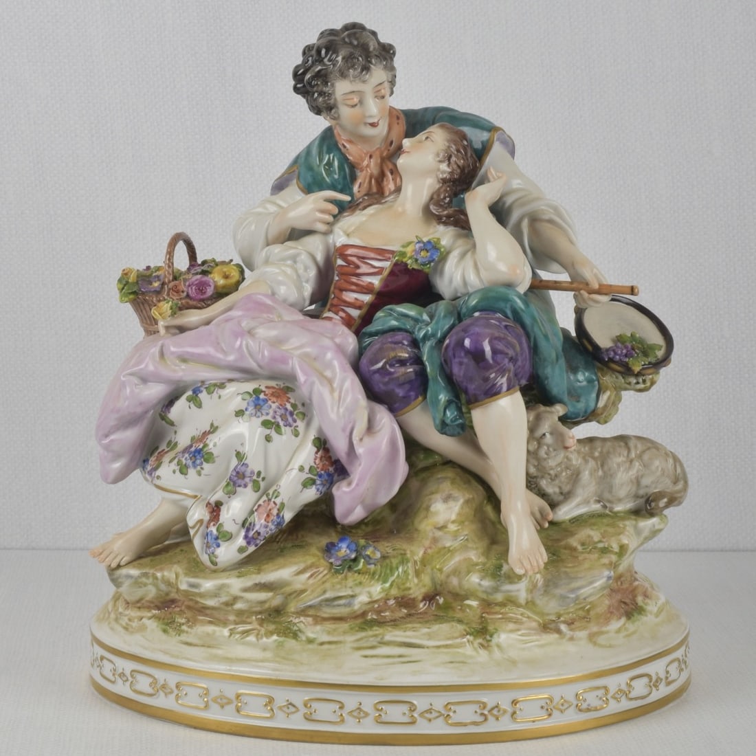 German Rudolstadt Volkstedt: German Rudolstadt Volkstedt Porcelain Figurine. Depicting a lady and musician, accompanied by a seated sheep. Properly marked to the undersides. Measures: 11-1/4" high, 10-1/2" wide, 8-1/4" deep. Kodn