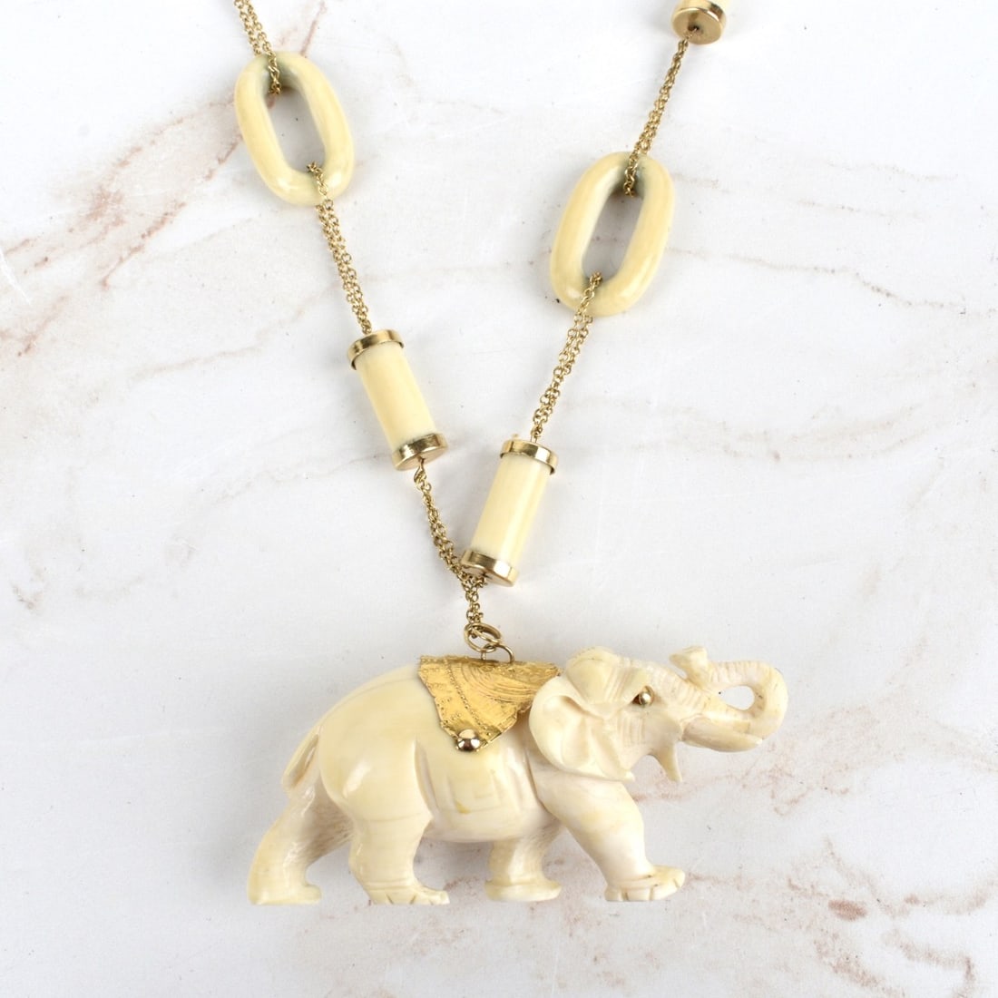 14K and Carved Elephant Pendant Necklace: Vintage Asian 14 karat Yellow Gold Carved Elephant Pendant Necklace with Beads and Loops. Clasp stamped 14K. Measures 30" L; elephant measures 1-1/4" H, 3" L. Approx. total weight: 74.84 grams. We