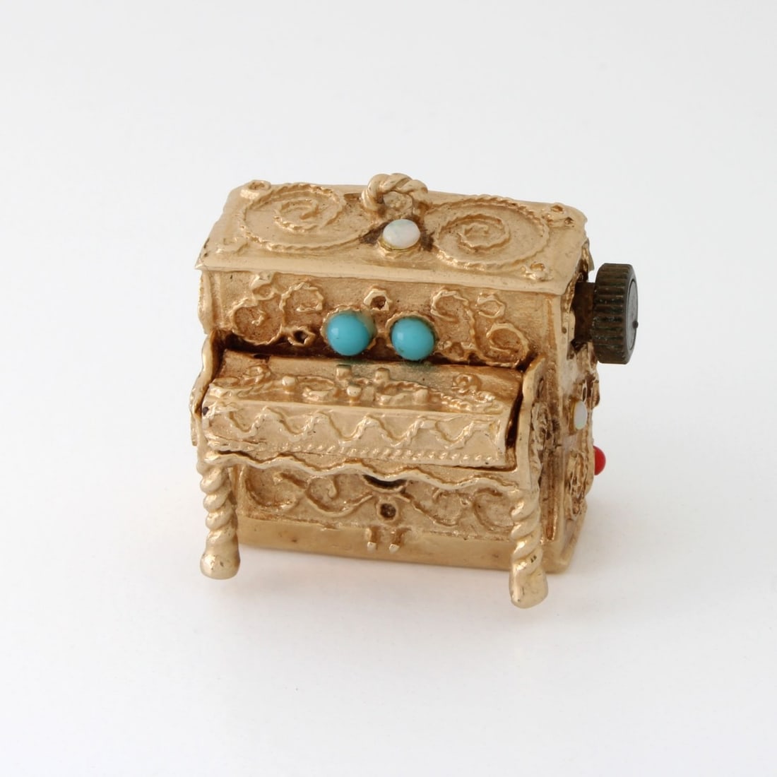 14K Piano Charm: Vintage 14 Karat Yellow Gold Musical Figural Piano Charm Inset with Small Turquoise, Opal and Coral Accents. Measurers 7/8" H, 1" W. Approx. gross weight: 26.62 grams. Kodner Galleries offers phone