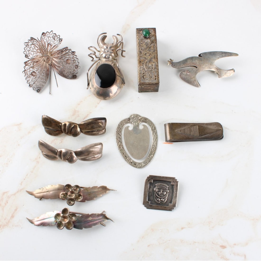 Lot of Antique Sterling Silver and Silver Pieces: Lot of Antique Sterling Silver and Silver Pieces. Including a lipstick holder with mirror, butterfly brooch, pins, 925 silver money clip, weighs 18.00 grams, 925 beetle brooch with inset stone, total