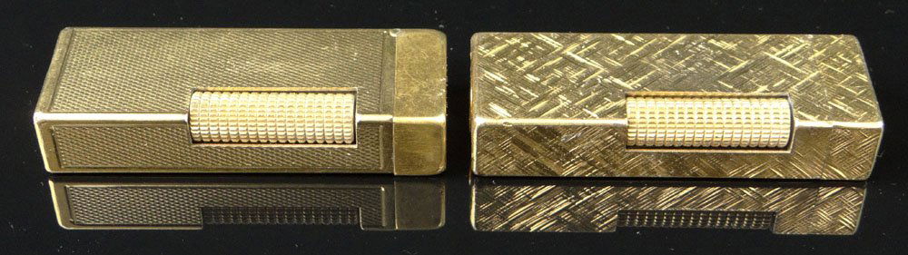 Two (2) Vintage Swiss Dunhill Gold Plated Butane: Two (2) Vintage Swiss Dunhill Gold Plated Butane Cigarette Lighters. Signed. Surface Wear from Use and Not Working, Please Examine this Lot Carefully Before Bidding. Measure 2-1/2 Inches Tall and 7/8