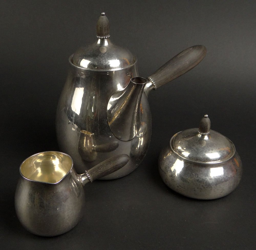 Three (3) Piece Early to Mid 20th Century Danish Georg: Three (3) Piece Early to Mid 20th Century Danish Georg Jensen Hand Hammered Sterling Silver and Ebony Chocolate Set Comprising: Chocolate Pot; Cream Pitcher and Covered Sugar Bowl. Signed and Numbered