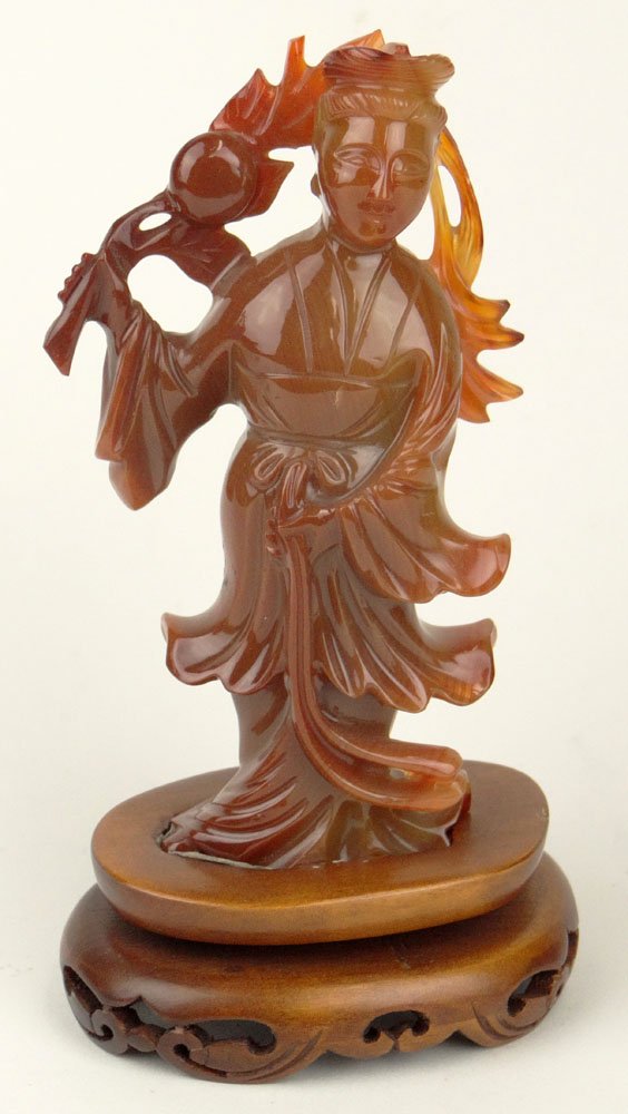 Chinese Carved Carnelian Guanyin with Carved Wood Base.: Chinese Carved Carnelian Guanyin with Carved Wood Base. Unsigned. Good Condition or Better. Measures 5-1/2 Inches Tall and 3-1/4 Inches Wide. Shipping $34.00