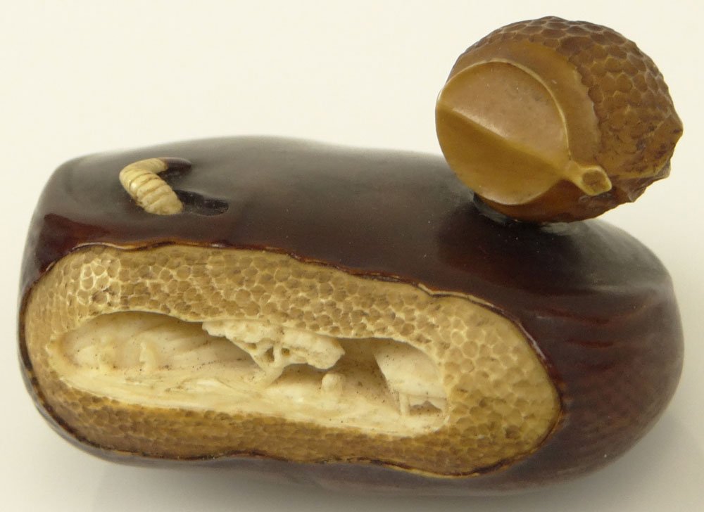 Very Fine Japanese Netsuke. Carved and colored to: Very Fine Japanese Netsuke. Carved and colored to resemble a Chestnut with a worm, also an opening in the center shows a very tiny village scene. The top adorned with another carved nut. Unsigned. Mea
