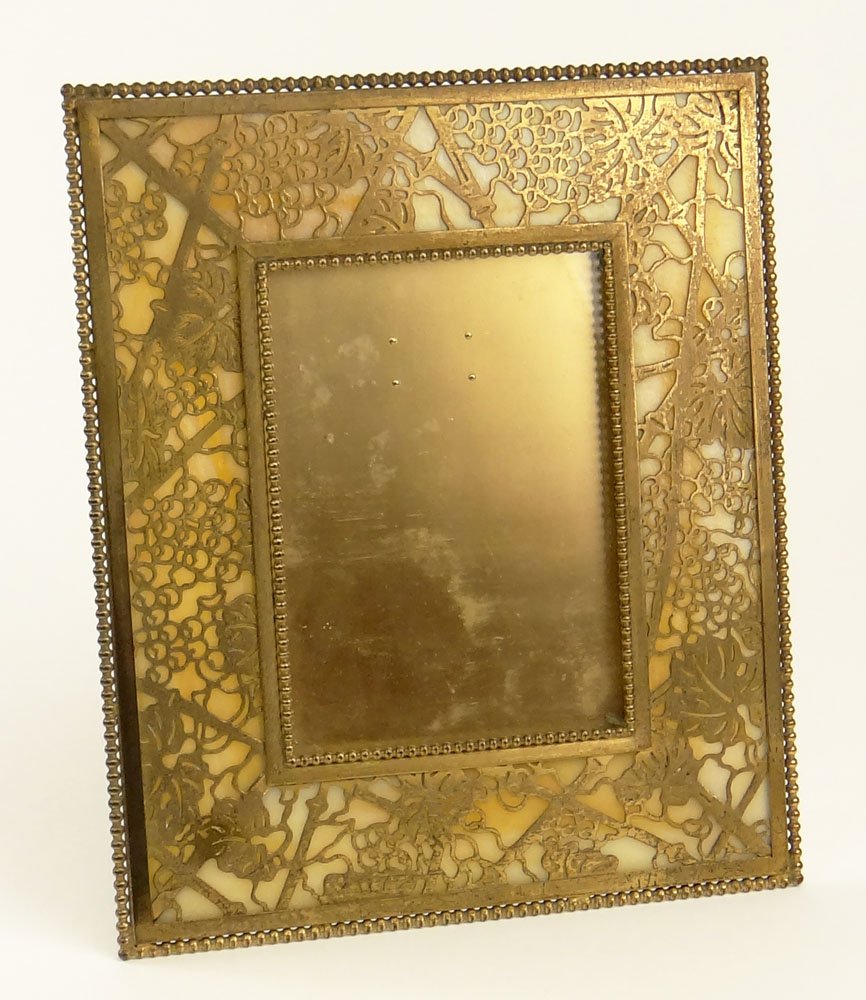 Tiffany Studios Desk Frame, Gilt Bronze in the: Tiffany Studios Desk Frame, Gilt Bronze in the Grapevine Pattern over Butterscotch Glass. Signed Tiffany Studios New York #947. One Piece of Glass is Cracked but intact or in Otherwise Good Condition.