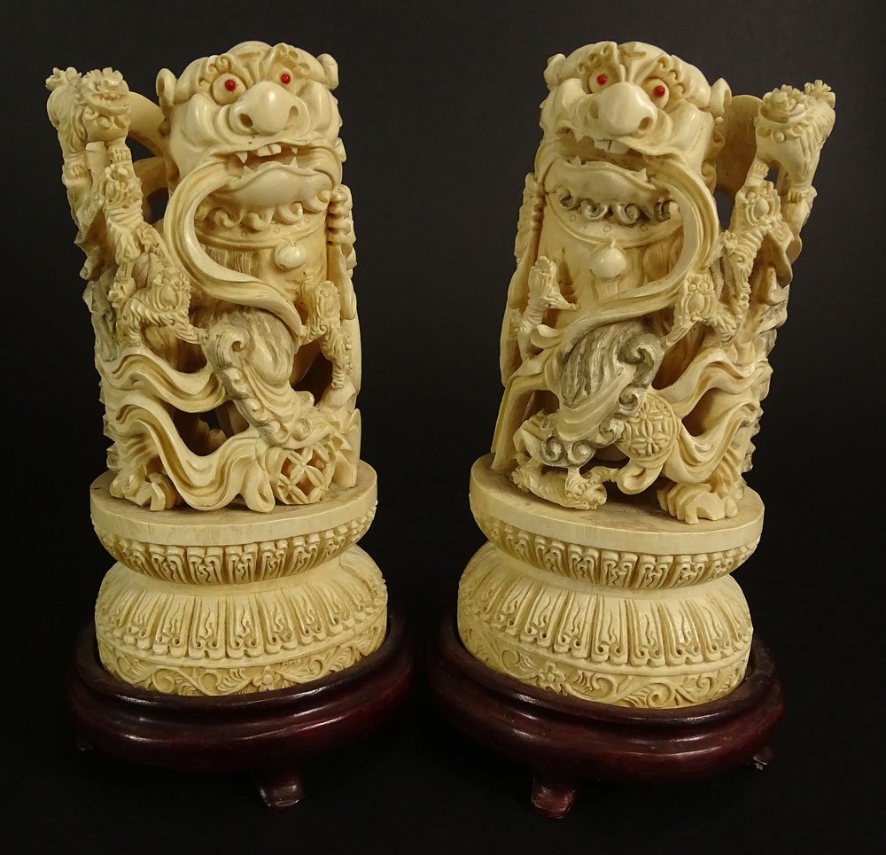 Pair Chinese Carved Ivory Foo Dogs on Hardwood Stands.: Pair Chinese Carved Ivory Foo Dogs on Hardwood Stands. Inset Coral Eyes. Deep Relief Carving. Unsigned. Typical Light Age Cracks or in Good Condition. Measures 10 Inches Tall, Including Bases. This it